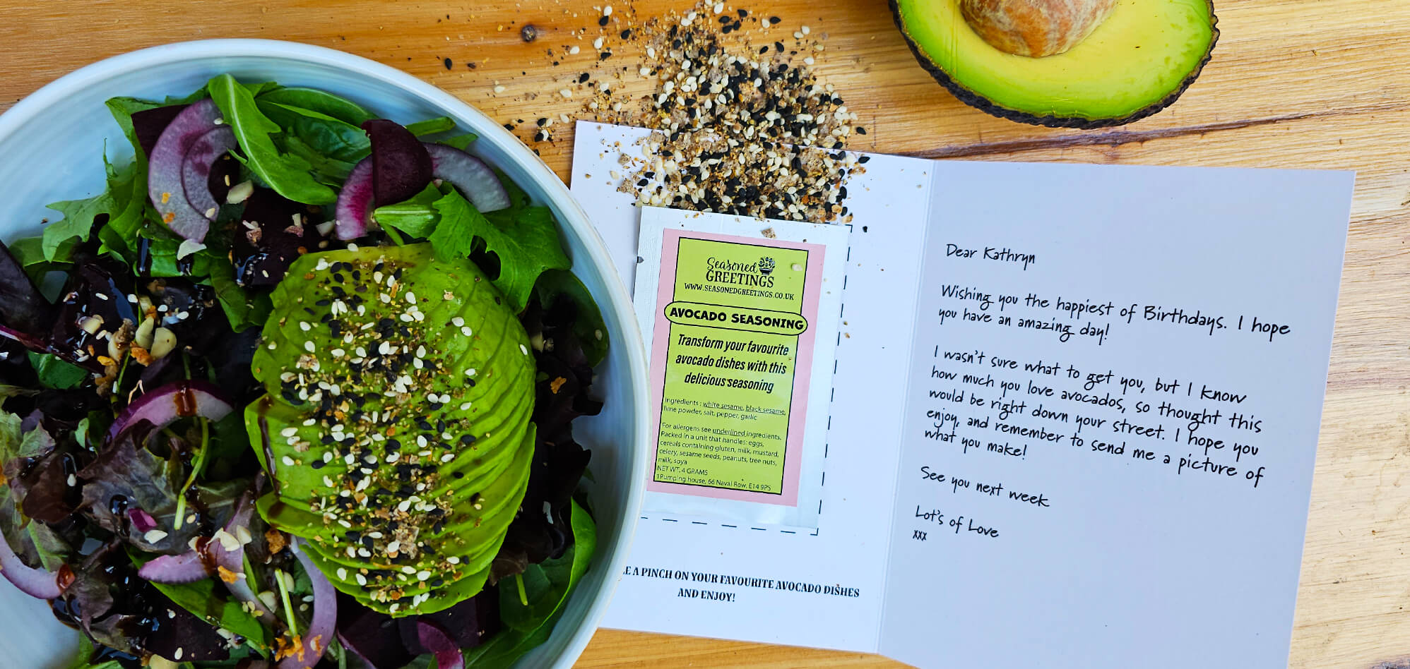 Close up of avocado salad. Next to it is an open greeting card with sachet of avocado seasoning inside